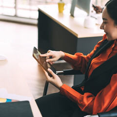 Obraz premium Young adult asian business woman use tablet in office on day.