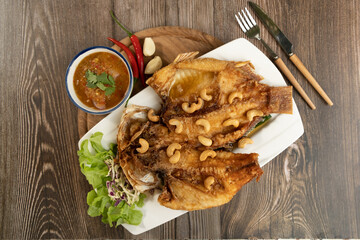 Fried Fish with Fish Sauce on the wooden background ready to eat