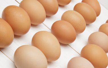 fresh chicken eggs laid out in rows on a white wooden table. selective focus.