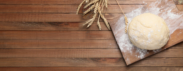Fresh dough on wooden background with space for text