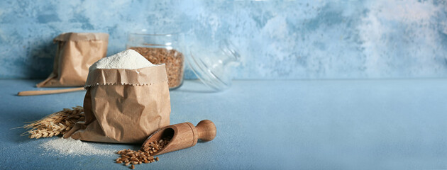Bag of wheat flour on color background with space for text