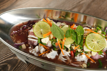 Steam Squid with Spicy Chili and Lemon Sauce - Pla Muk Nung Manow on wooden background ready to eat