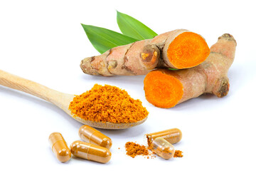 Turmeric herbal powder capsules and tumeric root with green leaf isolated on white background.
