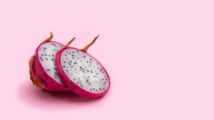 Two halves of a dragon fruit with white flesh. The pink pitaya fruit is low in calories, rich in essential vitamins and minerals, and contains dietary fiber.