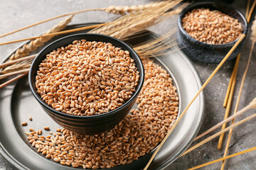 Bowls with wheat grains on grunge background