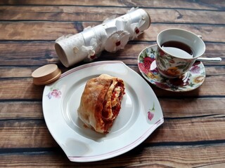 nd bun with jam and coffee next to a beautiful decorative box with a gift