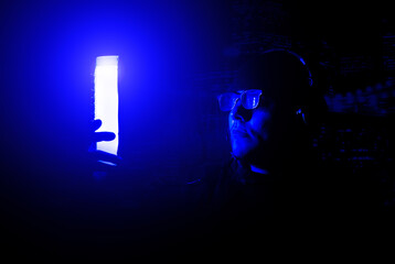 Obraz na płótnie Canvas Young man in glasses and headphones on the night party in nightclub with neon lights. Have fun tonight. Holidays entertainment.