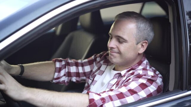 Relaxed Joyful Caucasian Man Dancing To Music Sitting On Driver's Seat In Car. Side View Portrait Of Happy Cheerful Smiling Guy Enjoying Hobby Waiting In Automobile. Lifestyle And Enjoyment.