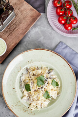 pasta with chicken cheese croutons and sauce on gray concrete background top view