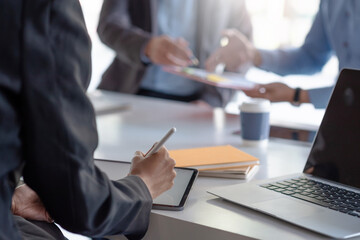 Close up of a businesswoman taking notes of the meeting using a tablet at the office.