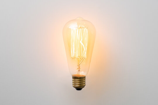 vintage light bulb glows without wires on white background