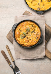 Frittata with mushrooms in a pan on wooden background. Fritata is an Italian breakfast dish.