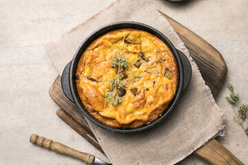 Frittata with mushrooms in a pan on wooden background. Fritata is an Italian breakfast dish.