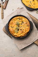 Frittata with mushrooms in a pan on wooden background. Fritata is an Italian breakfast dish.