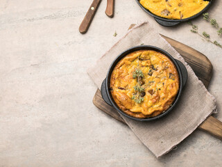Frittata with mushrooms in a pan on wooden background. Fritata is an Italian breakfast dish.