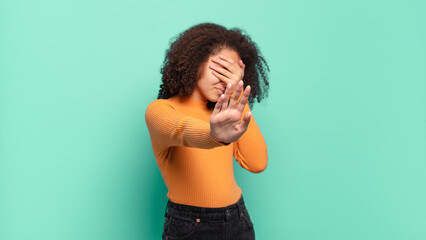  covering face with hand and putting other hand up front to stop camera, refusing photos or pictures