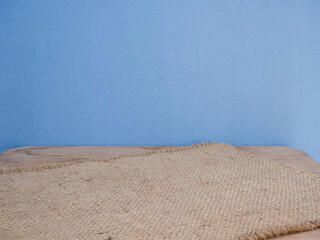 Sackcloth,burlap hessian  arrange on wooden table and blue cement wall background  with copy space