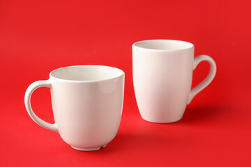 Empty cups on color background