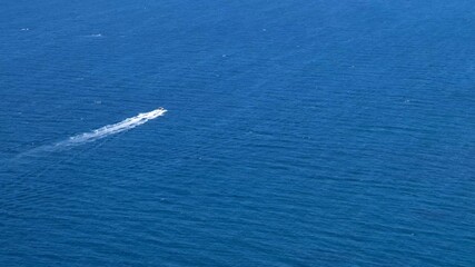 small boat moves on a beautiful blue sea