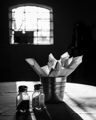 A pair of salt and pepper shakers, napkins on table