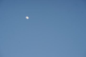 growing moon in clear blue sky during the day