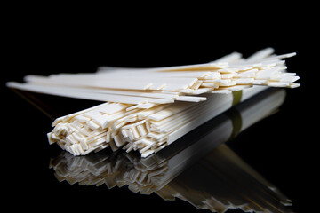 Uncooked chinese and japanese udon noodles on black table