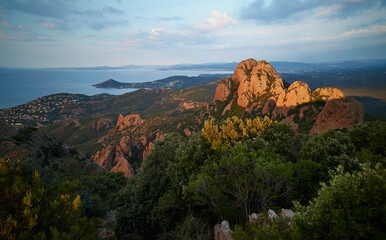 A wonderful view from the Pic du Cap Roux towards Cap du Dramont and Saint Raphael, shortly after sunrise. The mountains of the Esterel massif shine bright red. 