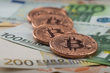 Bitcoin coins fall on euro banknotes. Crypto currency golden Bitcoin.euro.selective focus.close-up