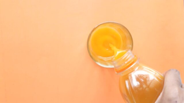 orange juice pouring from a bottle top down ,