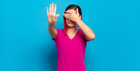  covering face with hand and putting other hand up front to stop camera, refusing photos or pictures