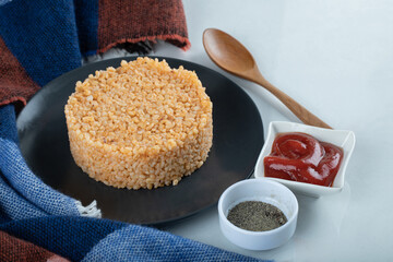 Delicious bulgur pilaf on a dark plate