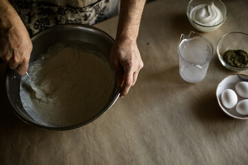 Male hands kneading batter in bowl
