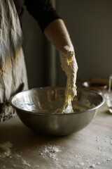 Male hands kneading batter in bowl