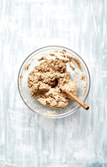 Bread dough in a glass bowl (wholegrain wheat bread with oat flakes). Flat lay
