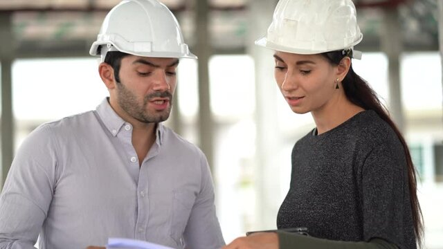architect man and foreman women discuss with tablet and paperwork on construction site . contractor worker Inspection with builder in house . couple checking house under Construction