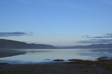 a view of the welsh mountains from ynyslas beach reflected in the estuary