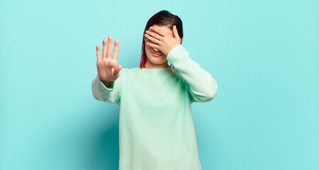  covering face with hand and putting other hand up front to stop camera, refusing photos or pictures