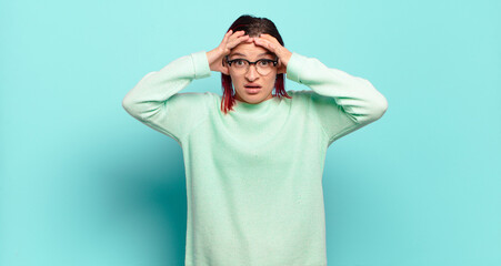  feeling horrified and shocked, raising hands to head and panicking at a mistake