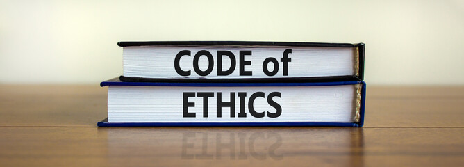 Code of ethics symbol. Concept words 'Code of ethics' on books on a beautiful wooden table, white...