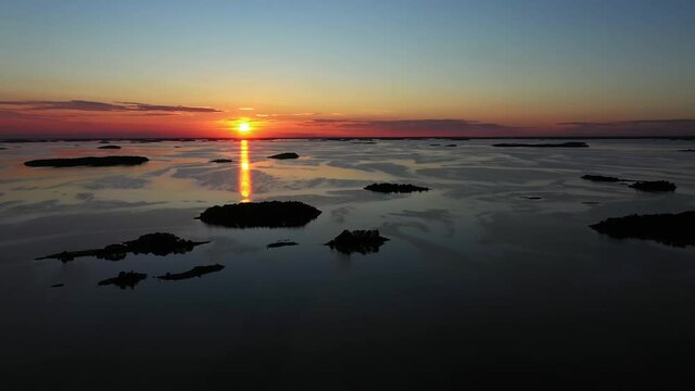 Aerial view over silhouette archipelago islands, sunset, at the Baltic sea, Scandinavia - tracking, drone shot