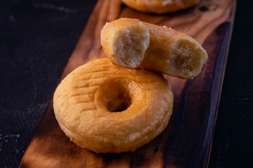 glazed donuts on wooden base with dark background