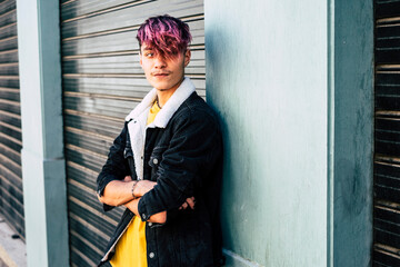 Portrait of handsome and young teenager boy man with violet diversity alternative hair look style - concept of modern people student age