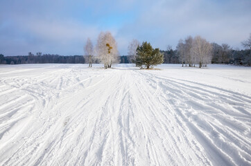 Obraz premium Winter landscape with country road covered with snow.
