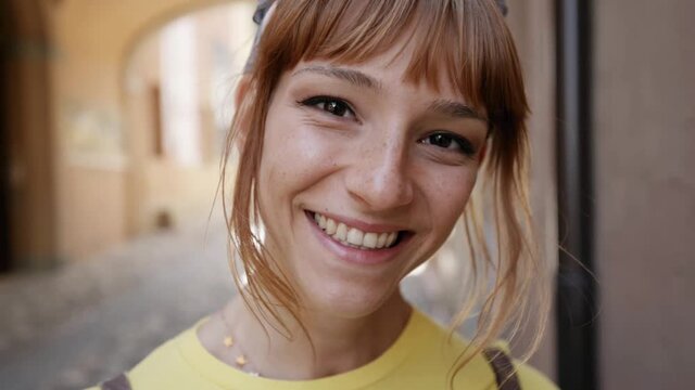 Beautiful young woman smiling at camera outdoor