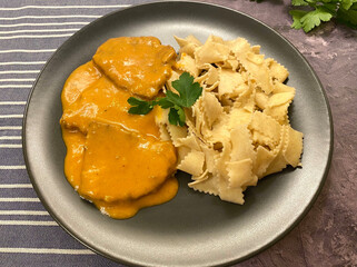 Beef schnitzel, also known as escalope, in tomato sour cream gravy. Served with tagliatelle pasta.