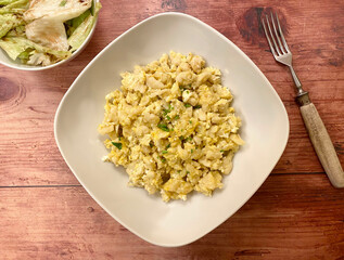Classic, vegetarian dish, egg with small shapeless dumplings, also known as nockerl or nokedli with iceberg salad and dressing.