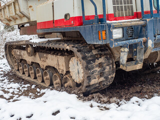 Fototapeta na wymiar Tracked dump truck with a steel body for transporting stones, soil or sand over difficult terrain.