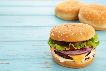 Homemade burger ingredients arranged on blue background