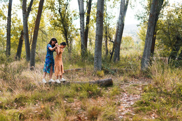 Fototapeta premium A couple of lesbians walking over a fallen tree