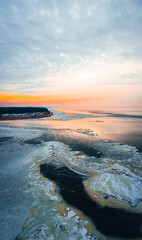 Aerial view on frozen seawater at a beautiful sunset against a blue sky, winter by the sea